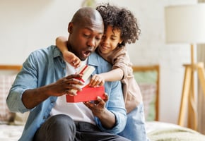 Young child surprising father with a Father's Day gift card