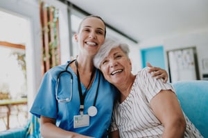 Happy healthcare worker hugging healthcare program member