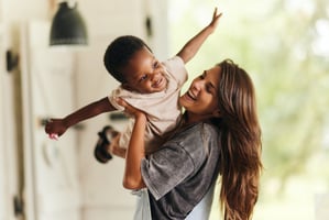 Happy mother playing with young child