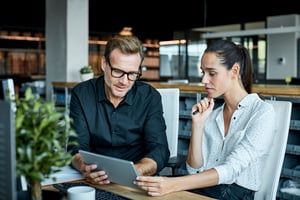 Male and female colleagues communicating in office setting