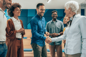 Satisfied employee after getting rewarded for great work shaking hands with the boss