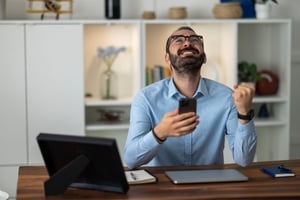 An employee rejoicing and feeling grateful after receiving an e-gift card from his employer