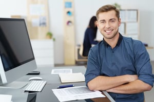 Smiling administrative assistant at his desk