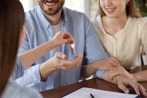 Smiling realty clients accepting keys to their new home