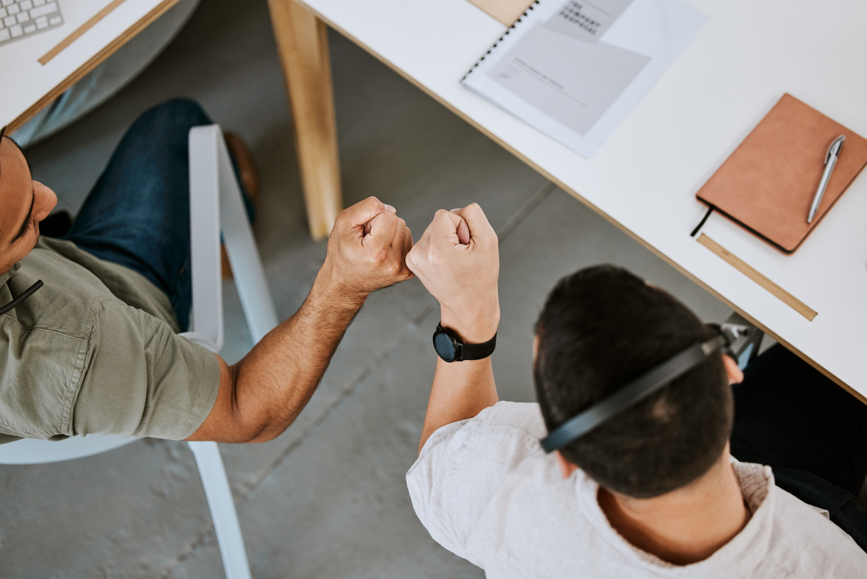 Two sales team members congratulating each other on success