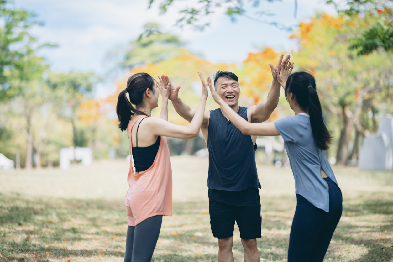 Smiling employees high-fiving after a workplace wellness challenge